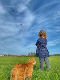 Rear view of woman on field against sky