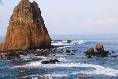 Stack rock in sea against sky