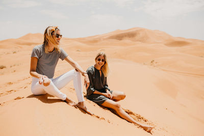 Full length of young woman on sand dune in desert