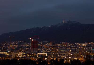 High angle view of illuminated buildings against sky at night