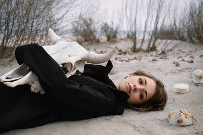 Portrait of young woman lying down on the beach