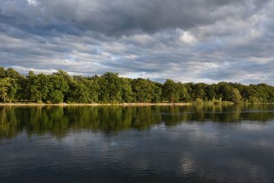 Scenic view of lake by trees against sky