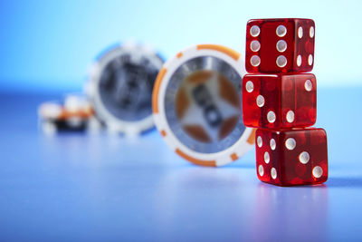 Close-up of red dices and gambling chips on table