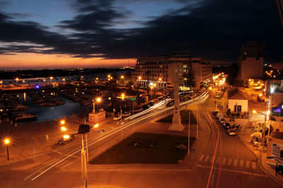 Light trails on road in city against sky at night