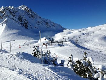 Scenic view of snowcapped mountains against clear blue sky