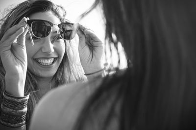 Close-up of female friends holding sunglasses