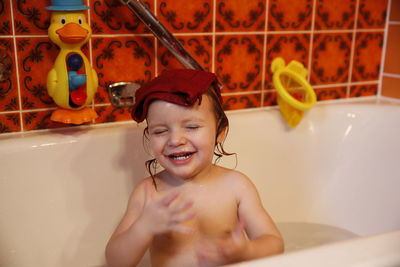 Happy girl in bathtub at home