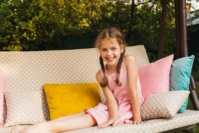 Portrait of smiling girl sitting outdoors