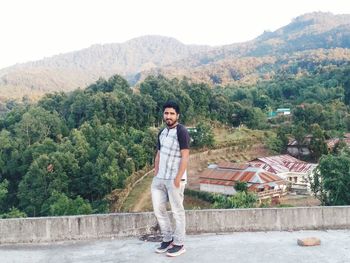 Portrait of smiling young man standing on mountain