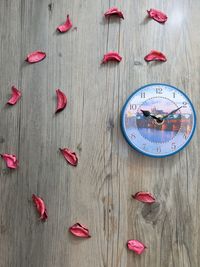 Close-up of clock and petals on table