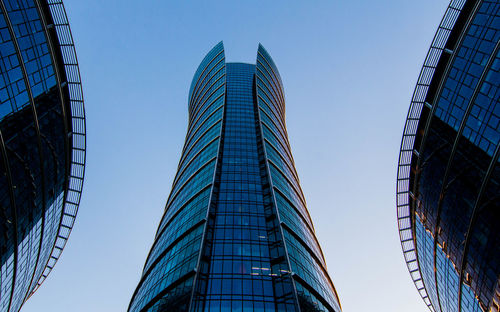 Low angle view of modern buildings against clear blue sky