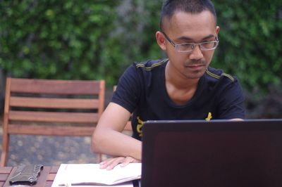 Man using laptop while sitting outdoors