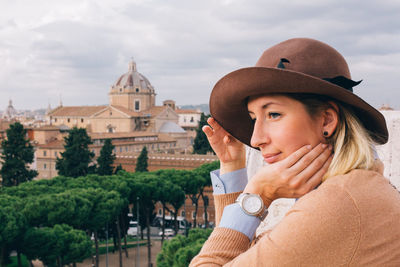 Portrait of young woman looking at camera against sky