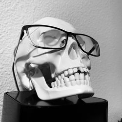 Close-up of eyeglasses with human skull on table