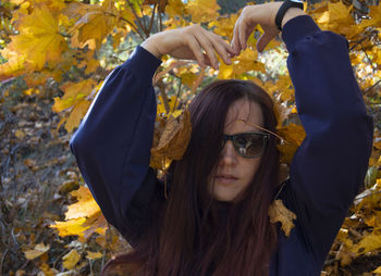 Portrait of young woman with autumn leaves