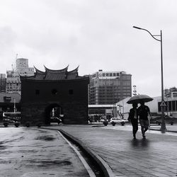 People walking on street against buildings in city