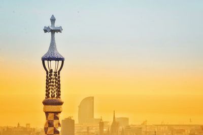 Statue in city at sunset