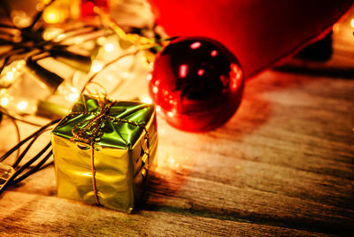 High angle view of gift box and illuminated string lights on table during christmas