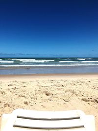 Scenic view of beach against clear blue sky