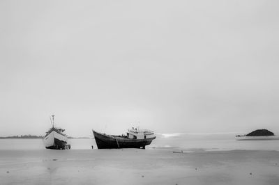 Fishing boats in sea against sky