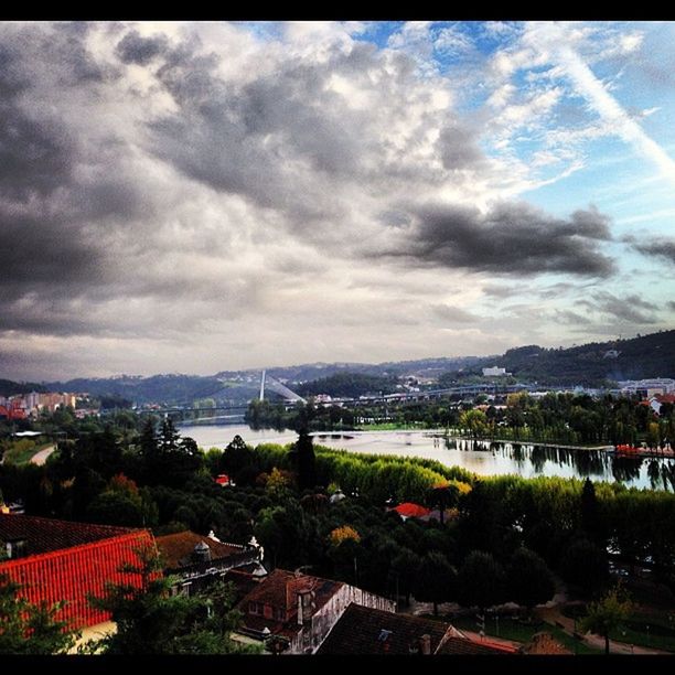 sky, cloud - sky, building exterior, architecture, cloudy, built structure, cloud, city, cityscape, tree, overcast, house, weather, residential district, residential structure, mountain, town, river, residential building, storm cloud