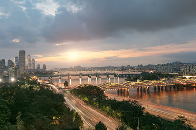 Bridge over river against sky at sunset
