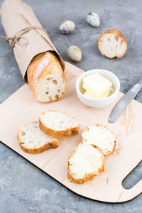 Tasty breakfast. fresh baguette sandwiches with butter and quail eggs on a cutting board