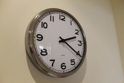 Close-up of clock on white wall