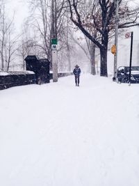 Woman walking on snow covered landscape