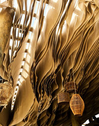 Aerial ceiling. light beige pieces of fabric in abstract movement. fresh breeze. straw lamps. airy