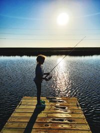 Rear view of child fishing  off bayou dock