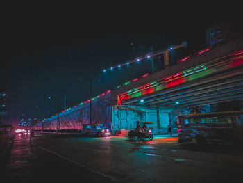 Low angle view of bridge against sky in city at night