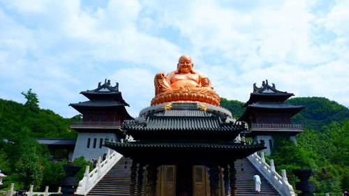 Low angle view of statues on building against sky