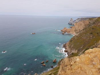 High angle view of rocks and sea against sky