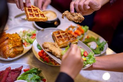 Cropped image of people having food at table