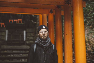 Portrait of man standing against wall