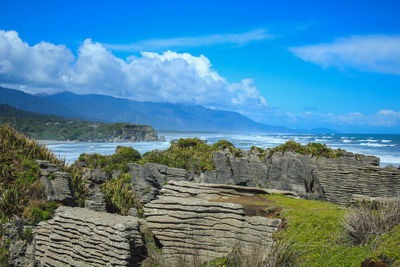 Scenic view of sea and mountains against sky