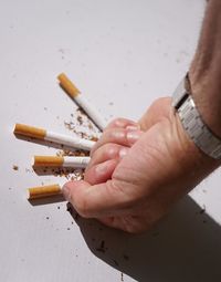 Close-up of hand crushing cigarettes