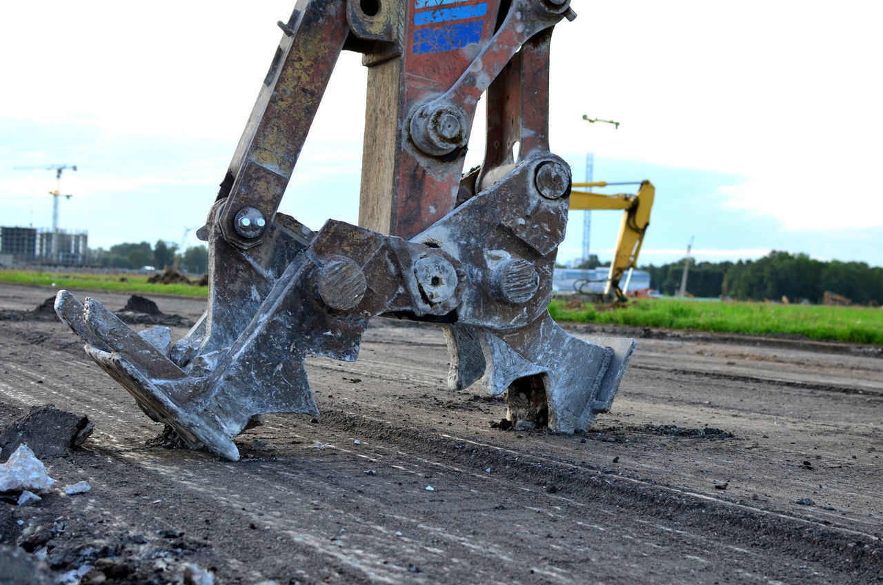 CLOSE-UP OF RUSTY MACHINE PART ON FIELD