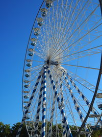 Low angle view of ferris wheel against blue sky