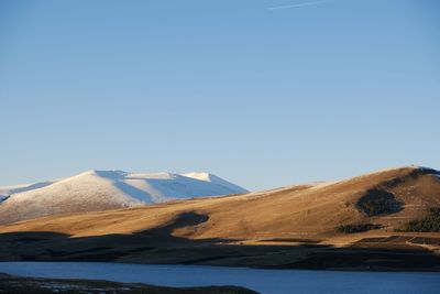 Scenic view of mountains against clear blue sky