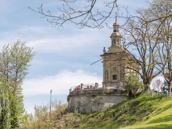 Tower amidst trees and buildings against sky