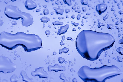 Close-up of water drops on blue surface