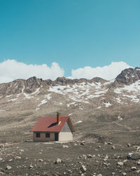 House on mountain against sky