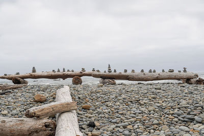 Stones on shore against sky