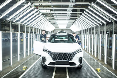 Two colleagues working in modern car factory