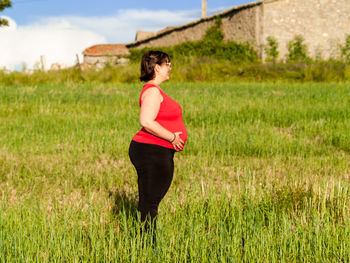 Pregnant woman standing on field