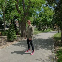 Portrait of young man skateboarding on footpath