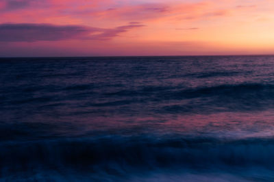 Scenic view of sea against dramatic sky during sunset