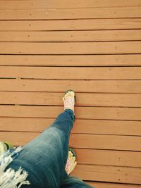 Low section of woman walking on boardwalk